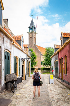 Enkhuizen, The Netherlands - July 7, 2021: Touris in traditional fishermans village with small houses a church and ships in Enkhuizen North-Holland in The Netherlandsのeditorial素材