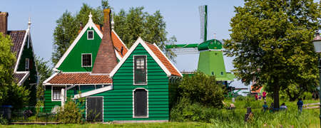 Zaanstad, The Netherlands - July 18, 2021: Panorama with traditional dutch gable house and windmills in Zaanse Schans Village in Zaanstad North Holland The Netherlandsのeditorial素材