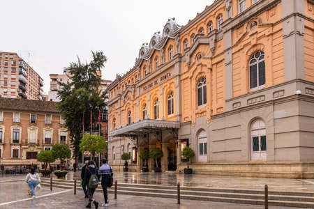 Murcia, Spain - March 30, 2022: Street scene with theater Teatro de Romea in Murcia in Spain during the evening on rainy dayのeditorial素材