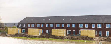Row of modern newly build family houses along canal in Kortenoord in Wageningen, Gelderland in The Netherlandsの写真素材