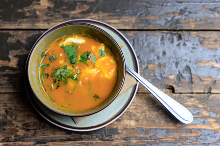 Colorfull Pumpkin soup with spoon on old brown wooden tableの写真素材