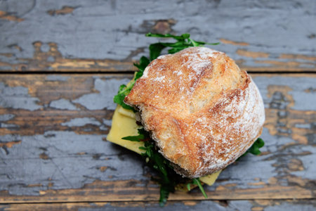 Top view of sandwich roll with Dutch cheese and rocket saladの写真素材