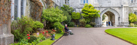 Cork, Ireland - April 17, 2023: Man at bench relaxing at bench in gardens University College of Cork Munster province in Ireland Europeのeditorial素材