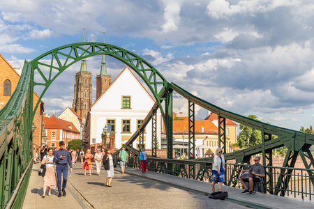 Wroclaw, Poland - July 20, 2023: People passing the Tumski bridge known as the lovers bridge to Tumski island and the cathedral in Wroclaw historical capital of Silesia in Polandのeditorial素材