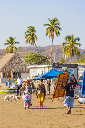 San Juan del Sur, Nicaragua - March 23, 2024: Sellers walking at beach to sell goods in San Juan del Sur coastal town on the Pacific Ocean in the Rivas department in southwest Nicaragua.のeditorial素材