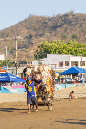 San Juan del Sur, Nicaragua - March 23, 2024: Sellers walking at beach to sell goods in San Juan del Sur coastal town on the Pacific Ocean in the Rivas department in southwest Nicaragua.のeditorial素材