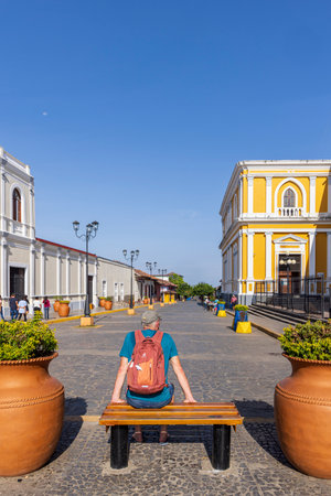 Granada, Nicaragua - March 19, 2024: Male tourist with backpack enjoying the view Beautiful Conception of Mary Cathedral Church in Granada Nicaragua Central Americaのeditorial素材