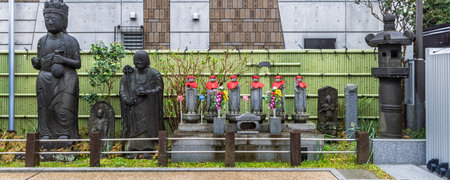 Row of Buddha statue at entrance of Saikoji temple in Yanaka subsurb in Tokyo, Japan. Yanaka is an atmospheric, traditional part of Tokyo known for its nostalgic atmosphere, temples, buddhas and cats.の写真素材