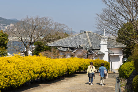 Tourist walking along the walkway enjoying Glover garden during spring in Minamiyamate hillside in Nagasaki in Japanの写真素材