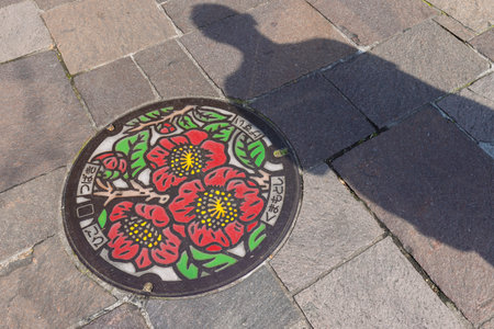 Kumamoto, Japan - March 24, 2025: Cover of manhole with Camelia flowers official city flower and known as Higo Camelia in Kummamoto in Japanのeditorial素材