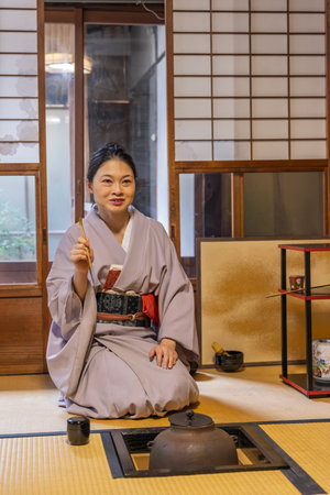 Kyoto, Japan: Japanese Woman in kimono demonstrating how to prepare trraditional matcha tea during a tea eremony in washitsu room with tatami mats and shoji sliding paper screens , Kyoto in Japan.のeditorial素材