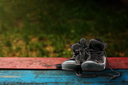 Old suede sneakers on a dark background.の写真素材