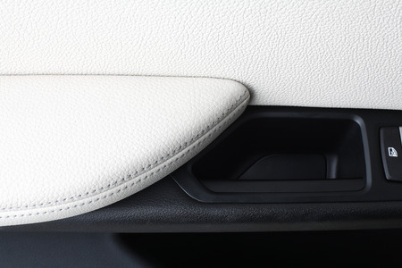 Interior of leather passenger compartment of the car in light tones.