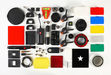 Workplace of the photographer. Photoaccessories set - lens cap, filters, frames, adapters, eyecups, remote shutter control, lens pen, flash diffuser, brush, bubble level, tripod, background clamps, macro tube, reflector.の写真素材