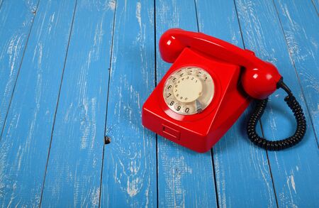 Vintage Phones - Red a retro telephone on a blue wood background.の写真素材