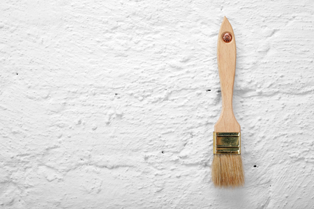 Construction, repair, tools - Paintbrush on a white brick wall backgroundの写真素材
