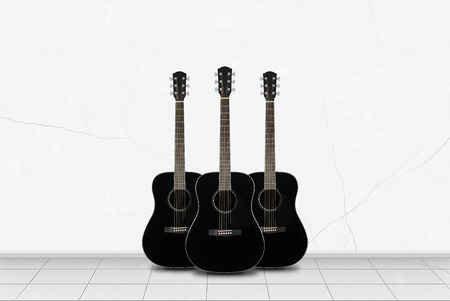 Home interior - Three black acoustic guitar in front on a white wall background