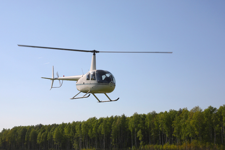 The aircraft - the small white helicopter at competitions makes flight at low height.の写真素材