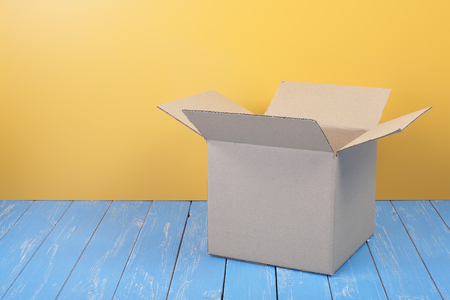 Postage and packing service - Open Package on a blue wood and yellow wall background.の写真素材