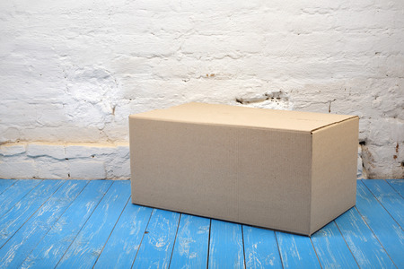Postage and packing service - Close Package on a blue wood and white brick wall background.の写真素材