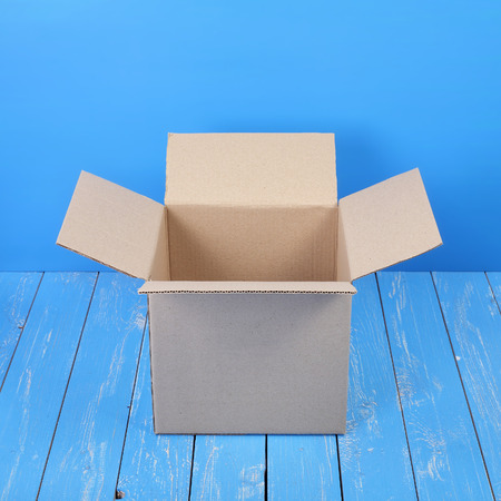Postage and packing service - Open Package on a blue wood background.の写真素材