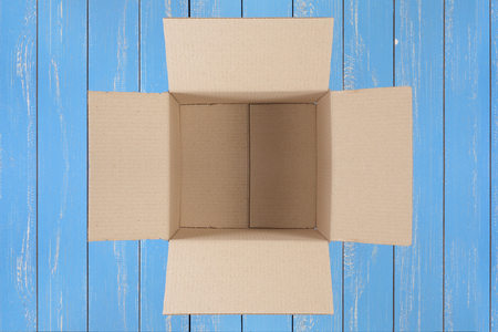 Postage and packing service - Open square Package top view on a blue wood background.