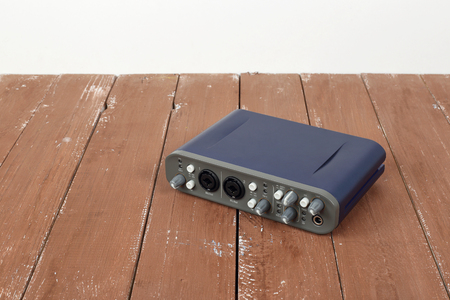 Music and sound - front view interface sound card on a white and wooden background.の写真素材