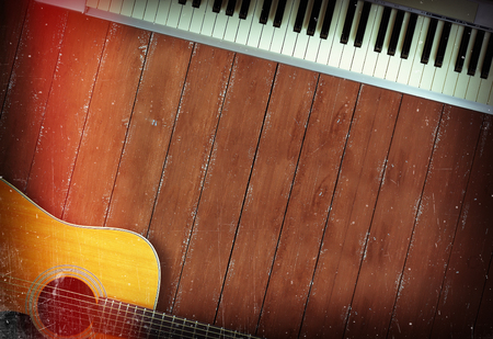 Musical instrument - Sloseup MIDI piano 61 key keyboard and acoustic guitar on a wooden backgroundの写真素材
