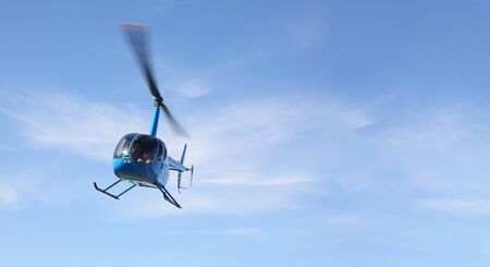 The aircraft - Front view blue helicopter makes flight at low height.の写真素材