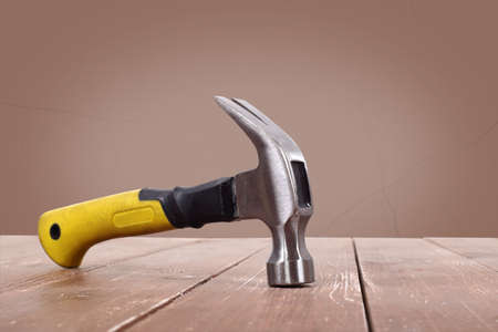 Tools Building and repair - Claw hammer on a wooden and brawn wall background.の写真素材