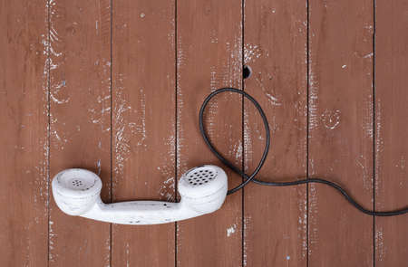 Top view White handset vintage phone on a retro old brown wood textured plank background