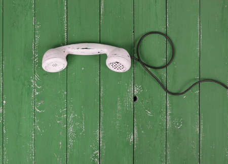 Top view White handset vintage phone on a retro old green wood textured plank backgroundの写真素材