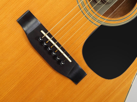 Musical instrument - Fragment top view pickguard, bridge, pins and strings vintage acoustic guitar.