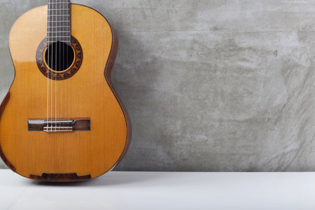 Musical instrument - Silhouette of a solid spruce top classic guitar on concrete background.