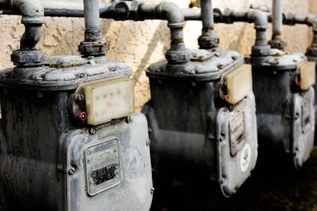 Multiple grundy gas meters on the side of an apartment complexの写真素材