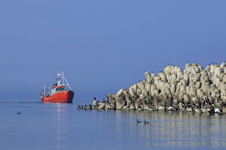 FISHING BOAT RETURN TO PORT. Fishing boat returning from the sea to the port of Kolobrzeg