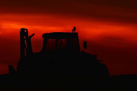 MULTIFUNCTION MACHINE - construction machine at dusk on construction siteの写真素材