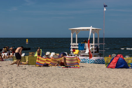 KOLOBRZEG, WEST POMERANIAN / POLAND - Tourists are resting on a sunny sea beachのeditorial素材