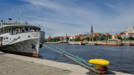 CITY ON THE RIVER - Small ship moored at the embankment of a promenade