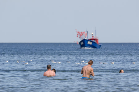 WEST POMERANIAN / POLAND: Beach holiday. Holidaymakers relax with a swim in the waterのeditorial素材