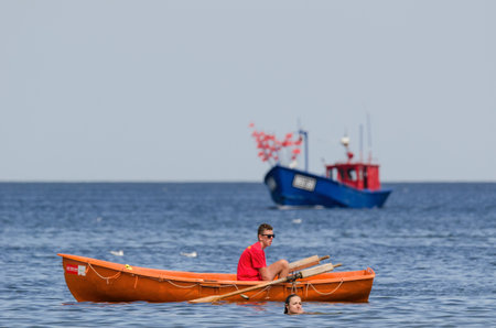WEST POMERANIAN / POLAND: Beach holiday. Holidaymakers relax with a swim in the waterのeditorial素材