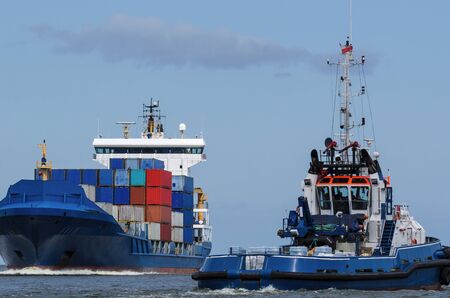 CONTAINER SHIP AND TUG - Shiping traffic near the portの写真素材