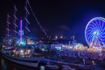 SZCZECIN, WEST POMERANIAN / POLAND: Final Tall Ships Races. Sailing vessel MIR and ferris wheel on the harbor quay at nightのeditorial素材