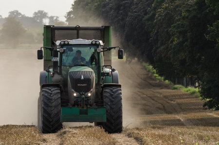 WEST POMERANIAN / POLAND: A modern tractor with a trailer on a farmlandのeditorial素材