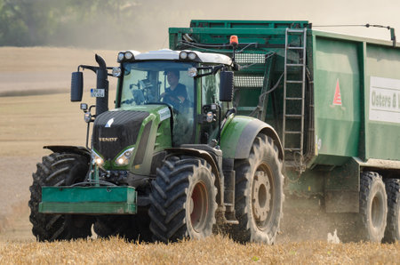 WEST POMERANIAN / POLAND: A modern tractor with a trailer on a farmland