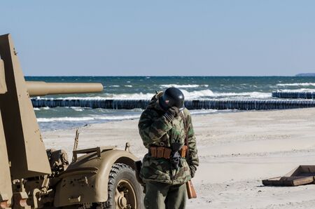soldier and anti-aircraft gun on the sea beachの写真素材