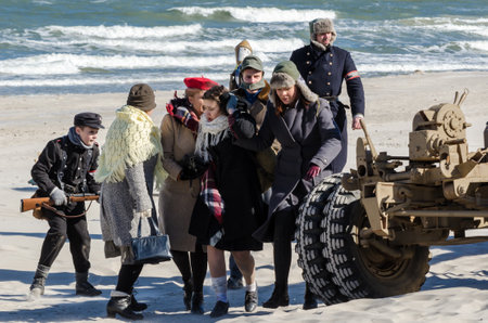 KOLOBRZEG, WEST POMERANIAN / POLAND - 2018: Reconstruction of battle for Kolobrzeg - Civilian escape through the sea beachのeditorial素材