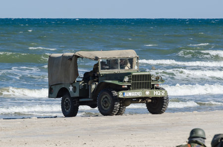 KOLOBRZEG, WEST POMERANIAN / POLAND - 2018: Reconstruction of battle for Kolobrzeg - Off-road vehicle on the Polish army on sea coastのeditorial素材