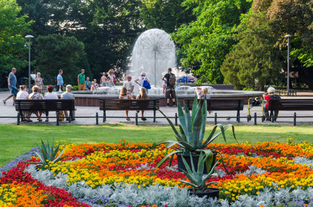 KOLOBRZEG, WEST POMERANIAN / POLAND - 2018: Residents and holidaymakers by the fountain in the city parkのeditorial素材