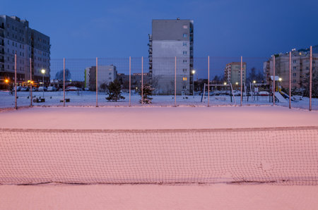 KOLOBRZEG, WEST POMERANIAN / POLAND - 2018: WINTER IN CITY - Snow-covered Tennis Court and the housing estate in the cityのeditorial素材